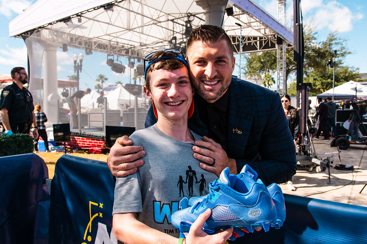 Tim Tebow with male teenager presenting a Brighter Day