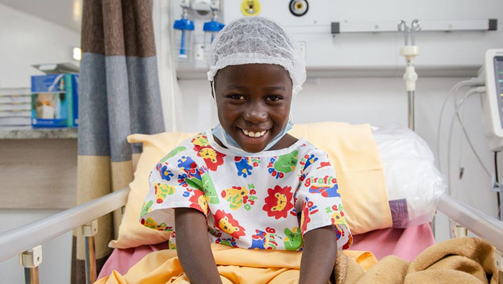 Girl sitting on hospital bed Smiling 
