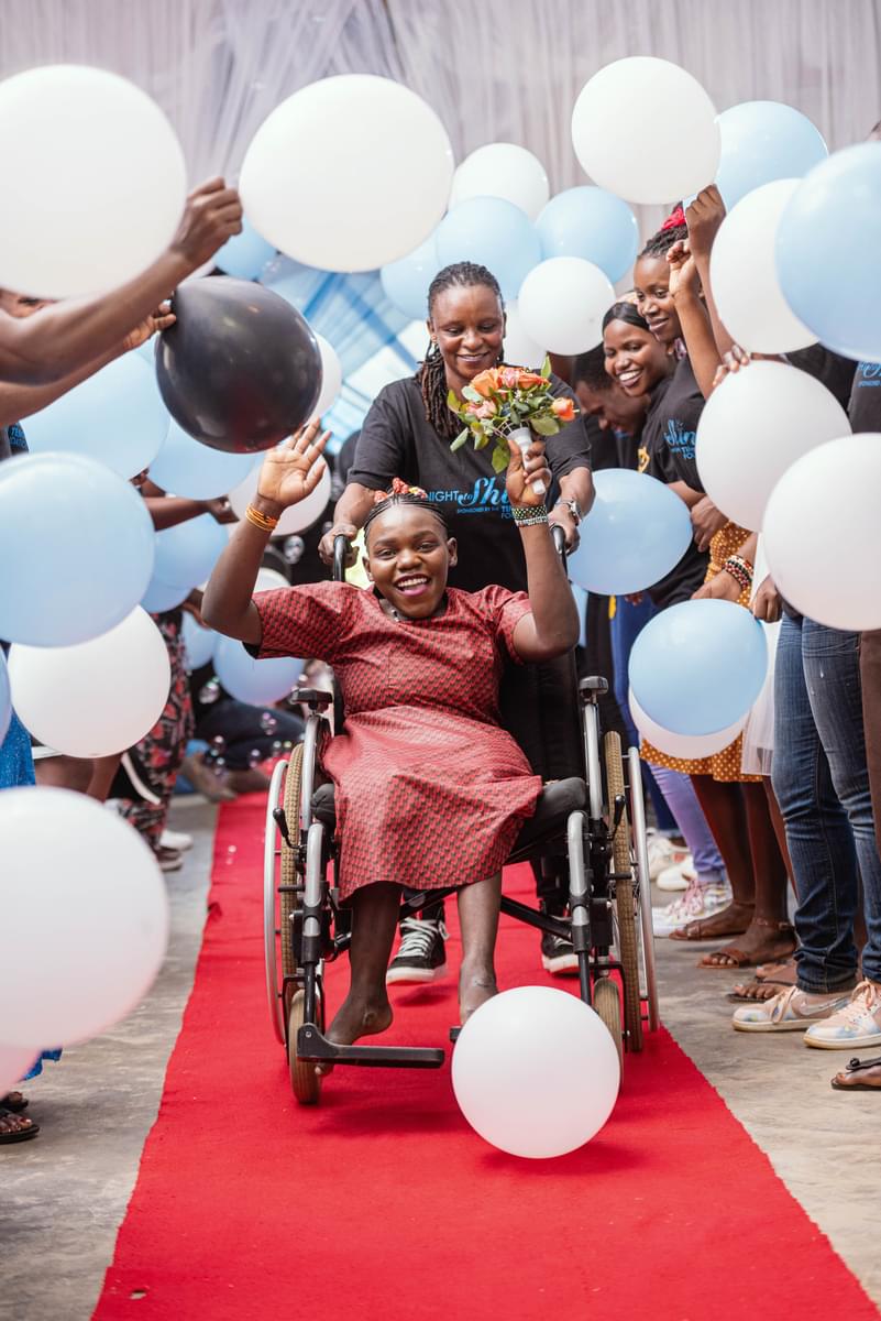 Female in wheelchair being celebrated on the red carpet at Night to Shine