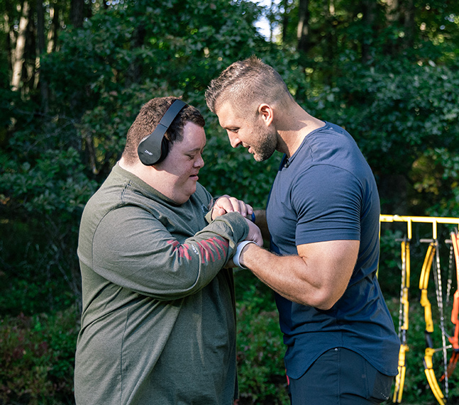 Tim Tebow and a young man wearing headphones